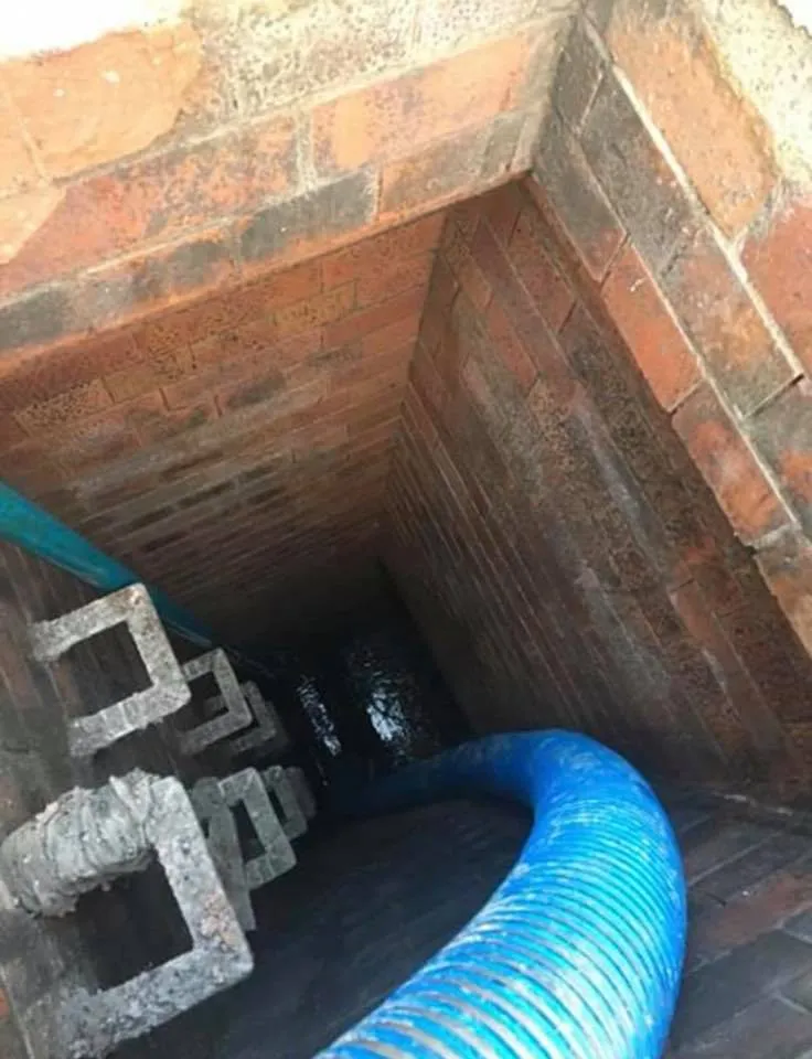 a blue pipe is coming out of a brick wall