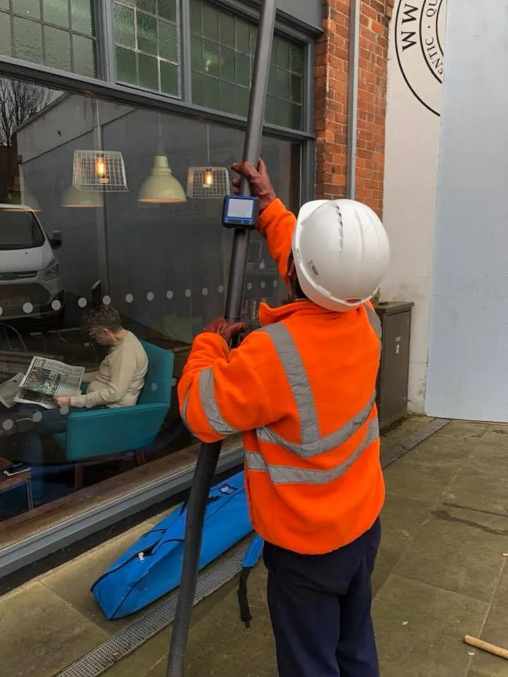 a man in an orange jacket is cleaning a window