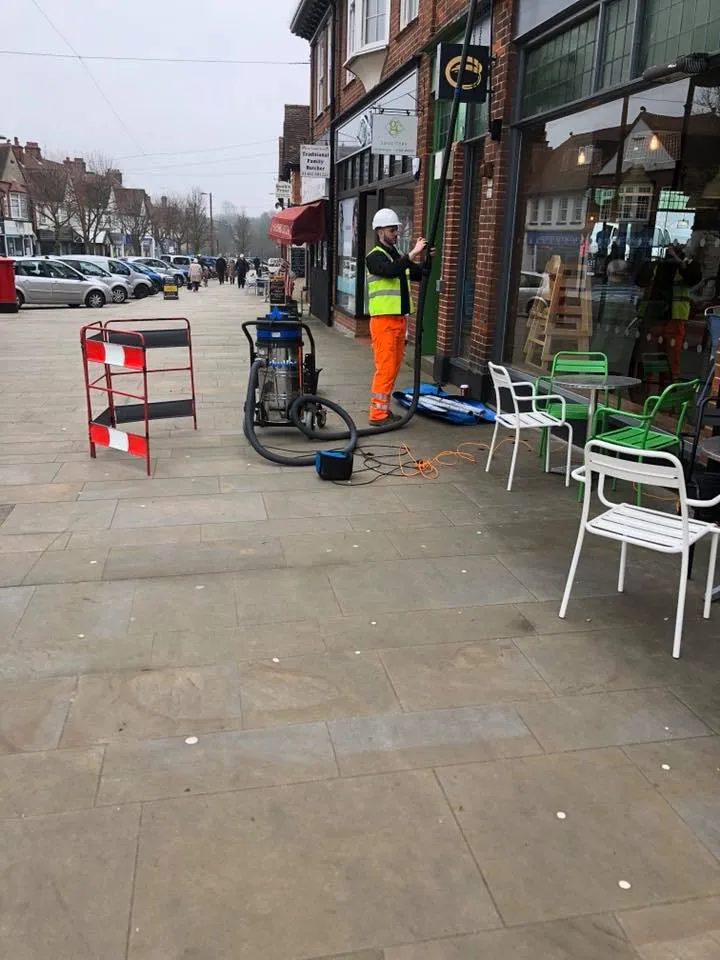 a man is cleaning a sidewalk with a machine