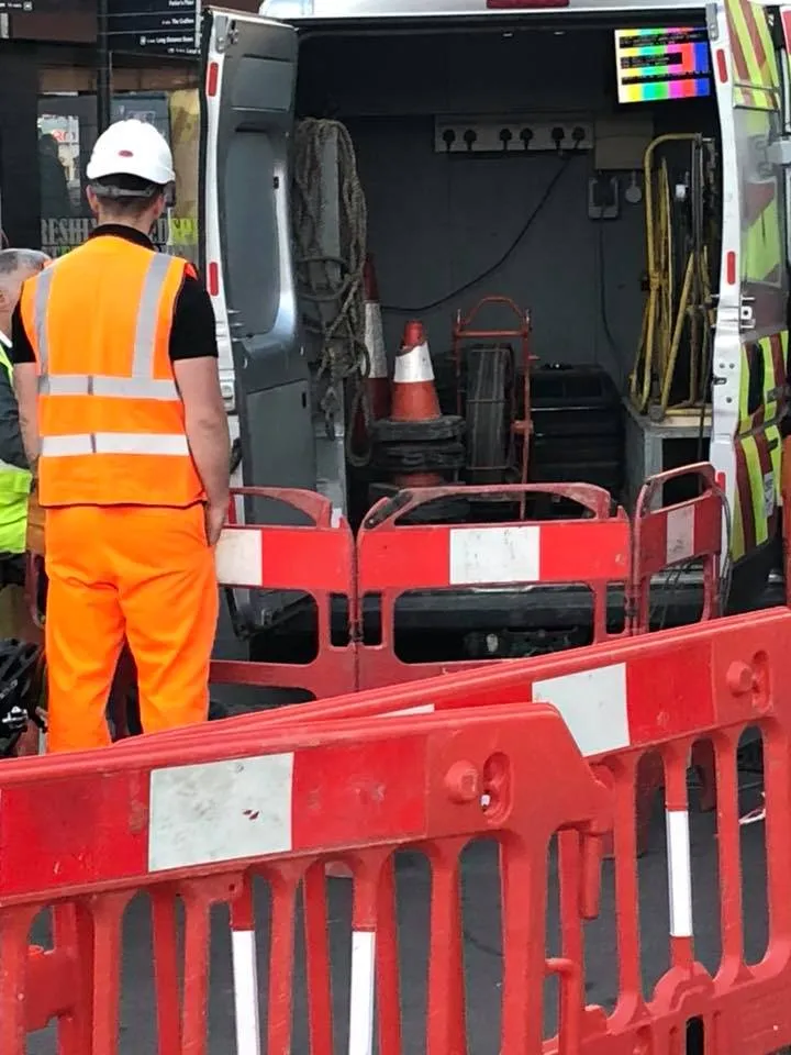 a man in an orange safety vest standing in front of a truck