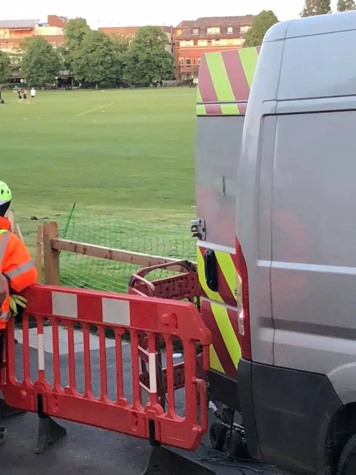 a man in an orange safety vest standing next to a truck