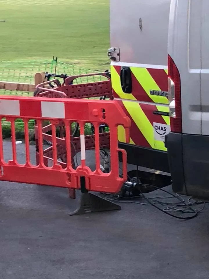 a white van parked next to a red and yellow barricade