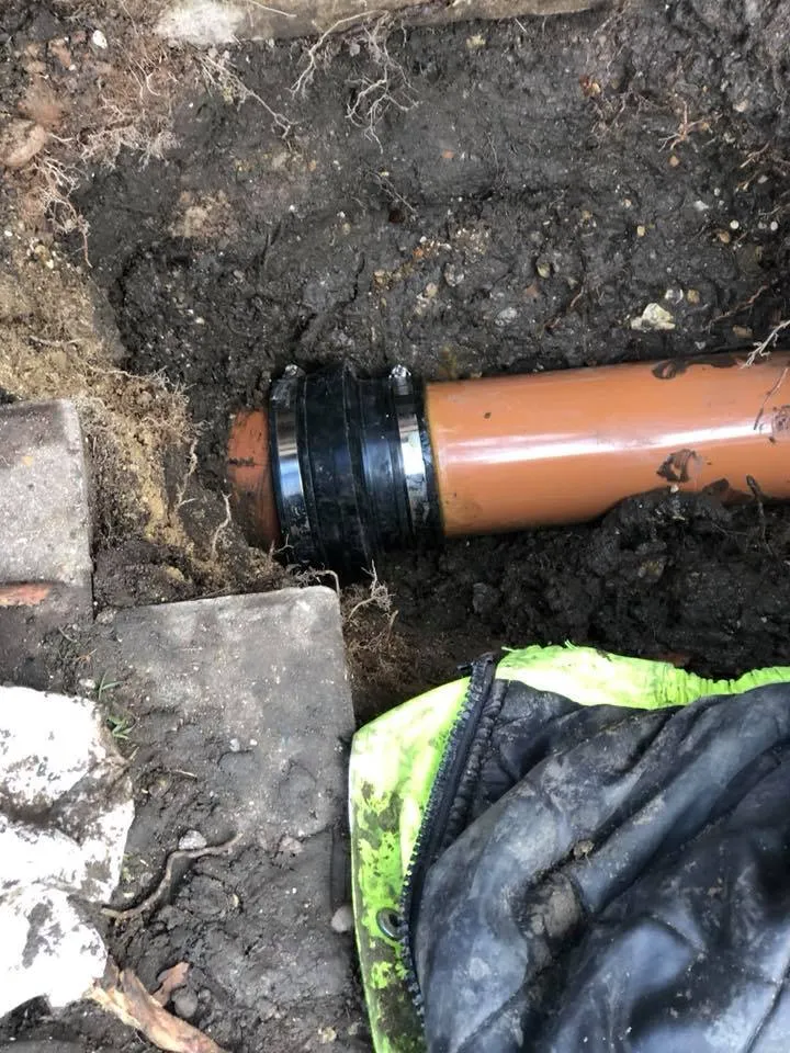 a pipe laying on the ground next to a bag